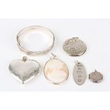 A collection of silver items
including an oval silver ingot, a stiff bangle, a heart shaped locket
