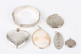 A collection of silver itemsincluding an oval silver ingot, a stiff bangle, a heart shaped locket