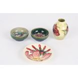 Four pieces of miniature Moorcroft
comprising a Hibiscus vase; a pair of small green ground floral