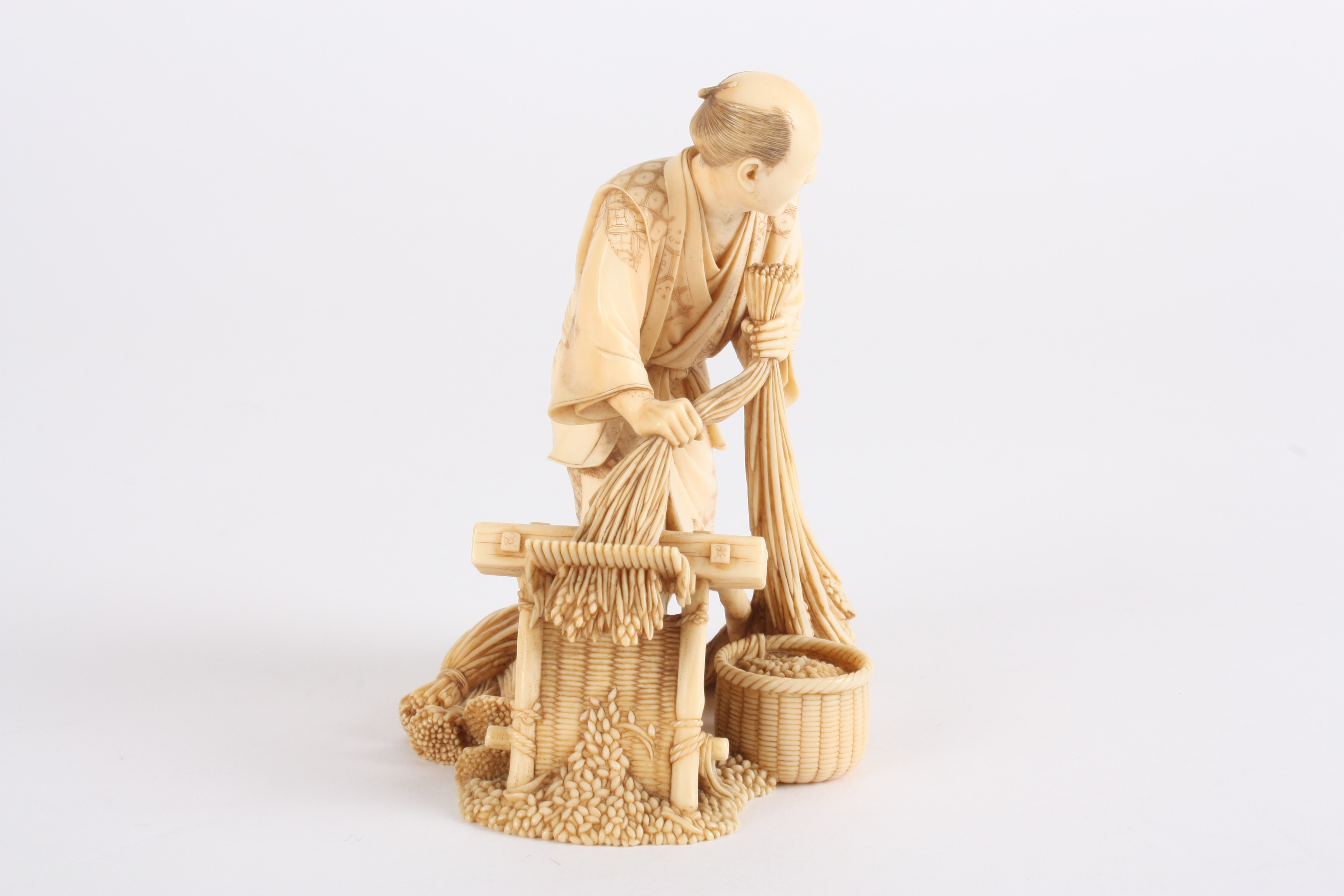 A Japanese finely carved ivory figure of a man
stood threshing corn using a foot operated machine, - Image 3 of 5