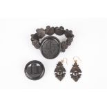 A Victorian carved bog oak suite of jewellery
comprising: a bracelet with carved central oval