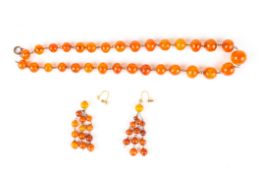 An amber coloured graduated bead necklacetogether with a pair of amber coloured bead earrings.
