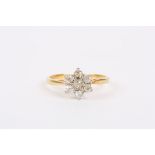 An 18ct gold and diamond ring
the diamond set in flower head, the central diamond set with six