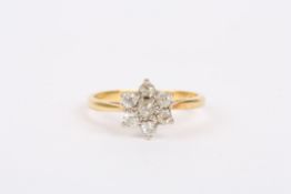 An 18ct gold and diamond ringthe diamond set in flower head, the central diamond set with six