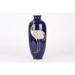 An early 20th century Japanese cloisonné vase
decorated with a crane in relief upon a rich blue