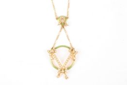 An Edwardian 15ct gold, seed pearl and green enamel pendantformed as a trio of ribbons on a green