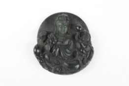 A Chinese Ming style carved dark spinach jade pendantfinely carved as a guan yin surrounded by