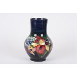 A Walter Moorcroft Iris bulbous vase
the body decorated with iris and other flowers on a blue