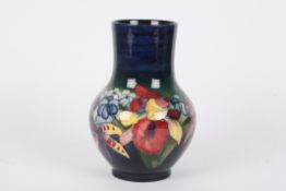 A Walter Moorcroft Iris bulbous vasethe body decorated with iris and other flowers on a blue