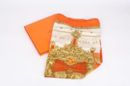 Two Hermès printed silk scarves in original boxes, one predominantly orange, cream, gold and