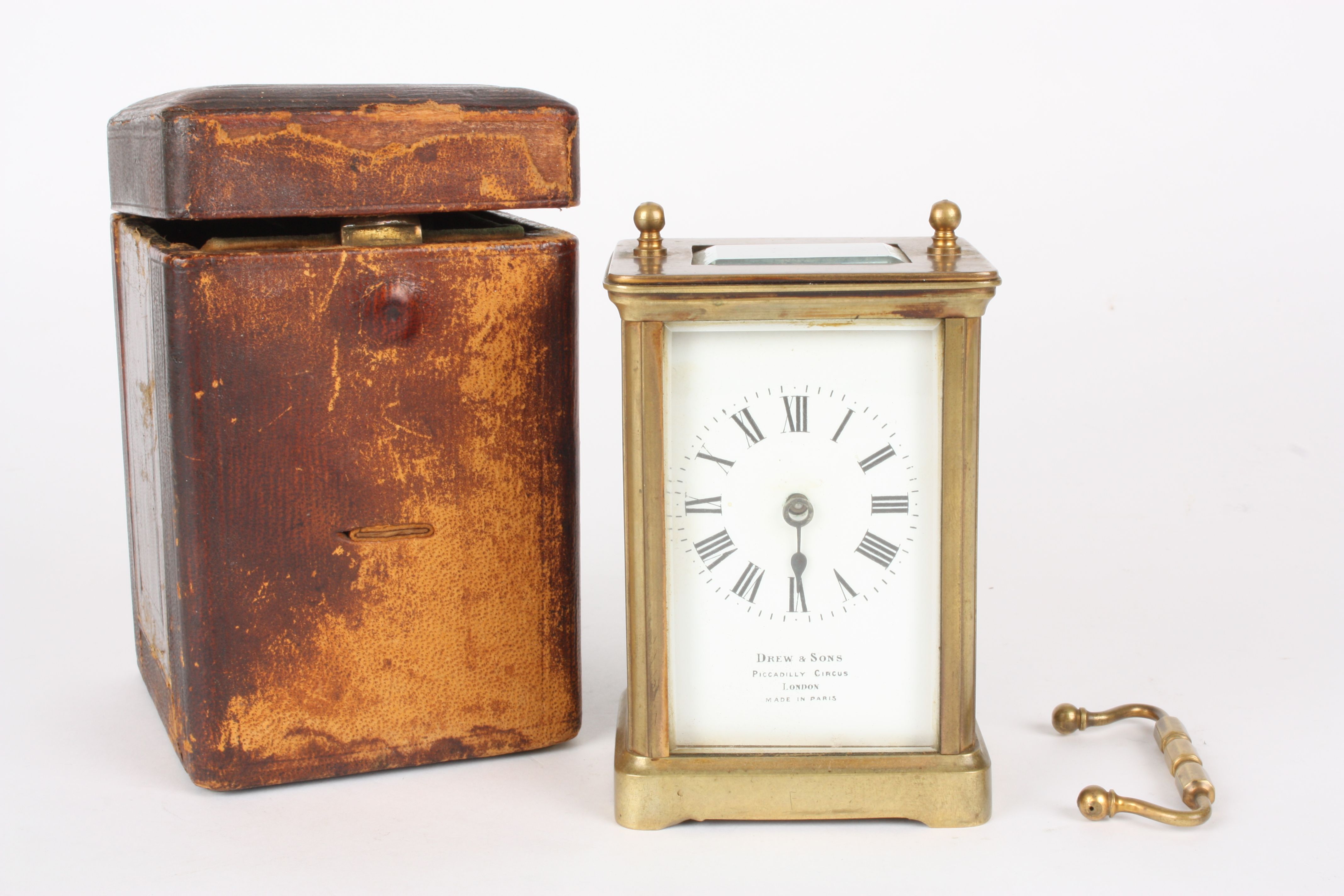 A French brass carriage clock
retailed by Drew & Sons, Piccadilly Circus, London, the plain brass