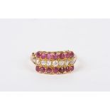A 9ct gold, diamond and ruby triple row cluster ring
set with two rows of rubies flanking a row of
