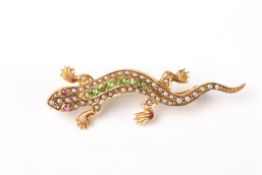 A charming Victorian 15ct gold peridot and seed pearl lizard broochin a naturalistic pose, set with