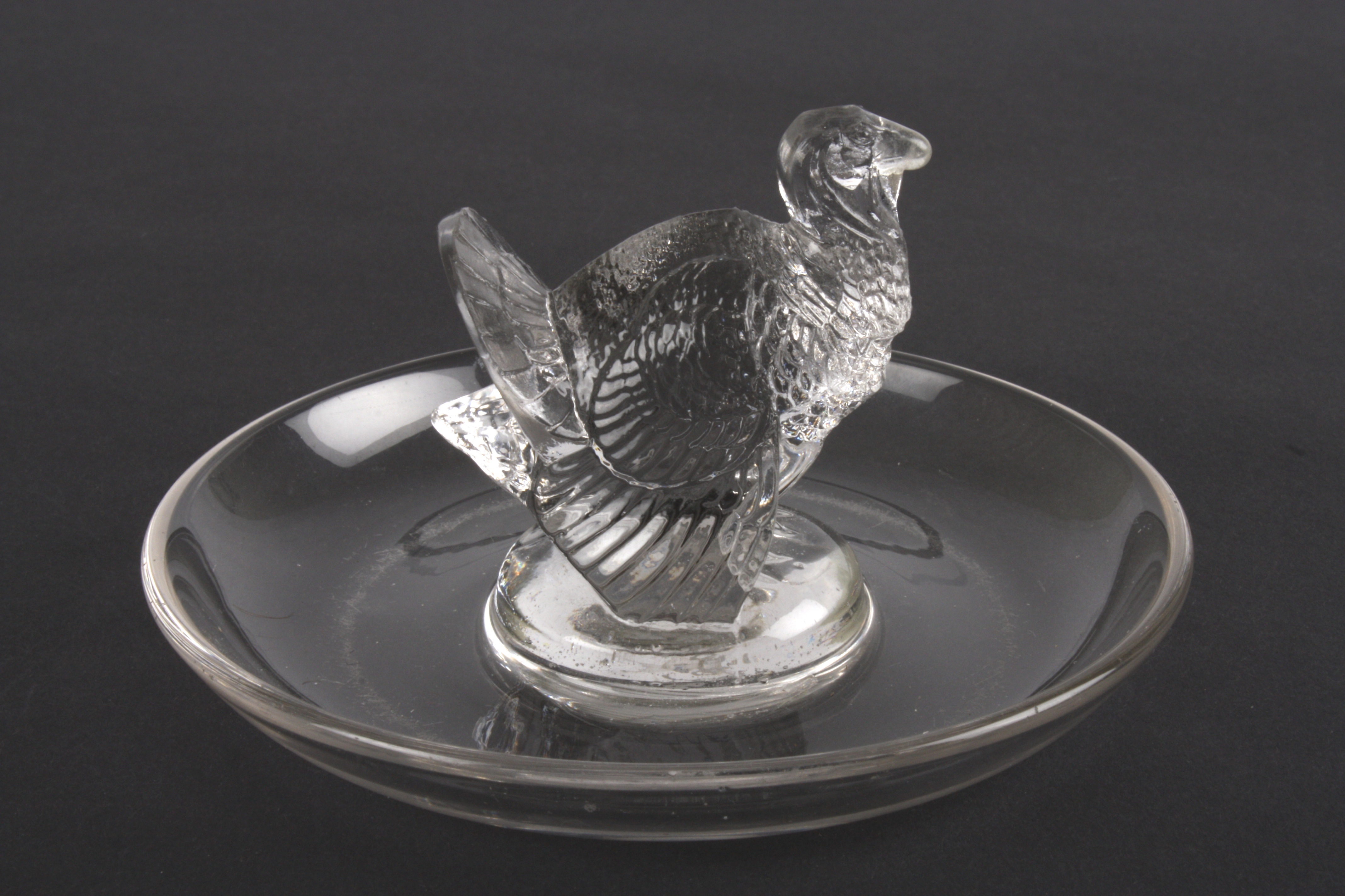 An R. Lalique clear glass ring dish
mounted with a model of a turkey. Etched signature to base 'R. - Image 2 of 3