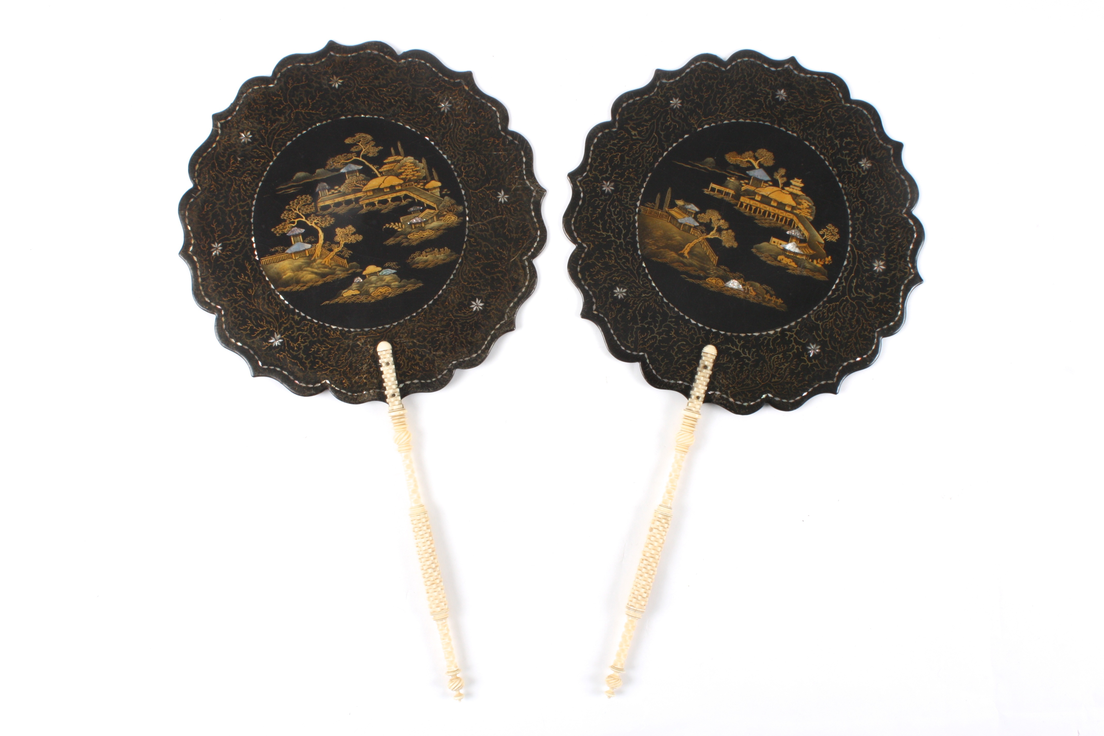 A pair of black lacquer Japanned fans
of shaped round paddle form decorated to the centre with