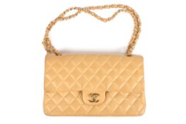 A leather quilted camel coloured Chanel bagthe leather double flap bag from Chanel featuring a