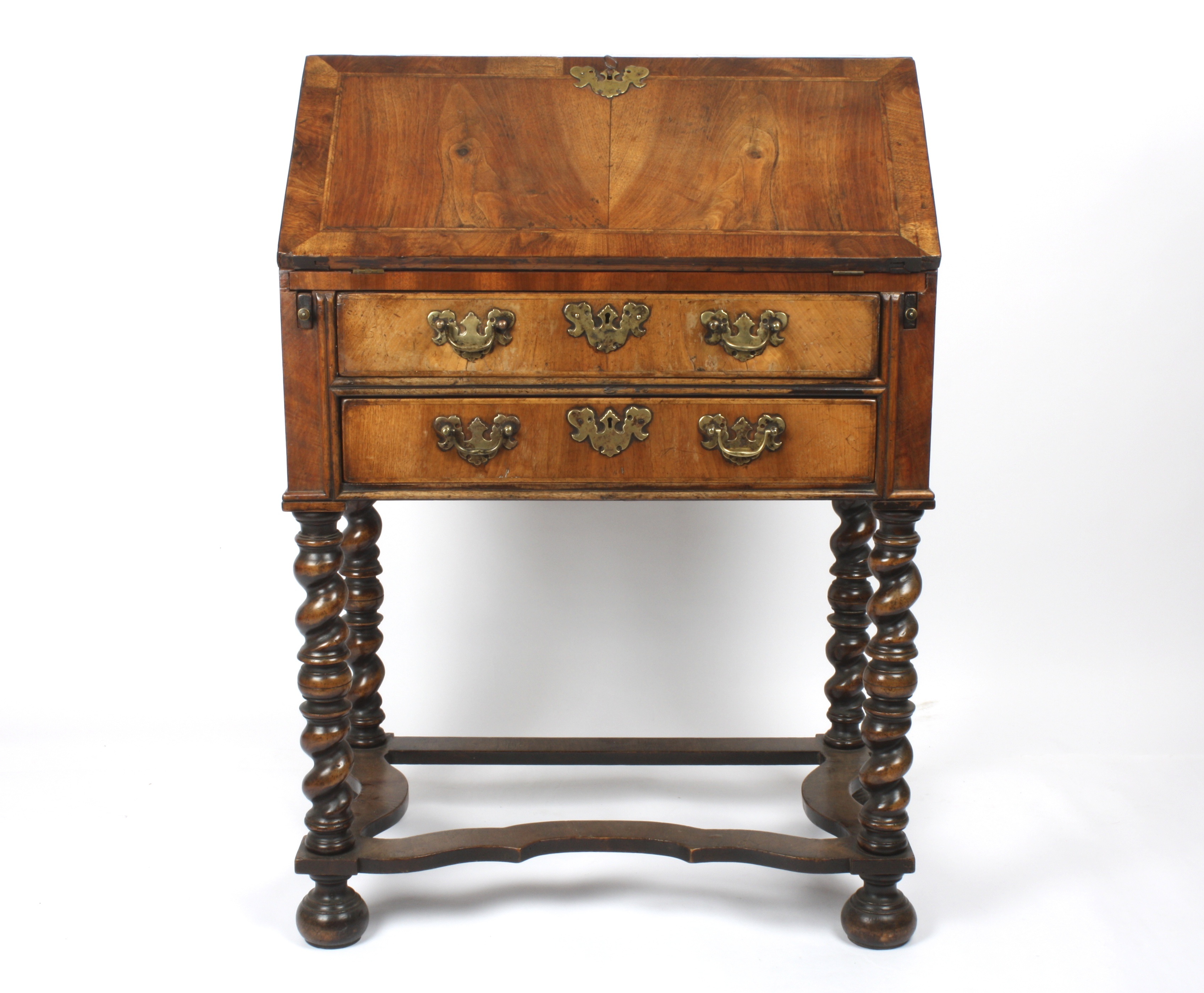 A 19th century walnut bureau on stand
the front lifting down to reveal a compartmented interior,