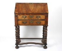 A 19th century walnut bureau on standthe front lifting down to reveal a compartmented interior,