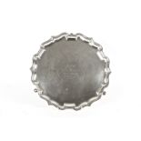 A silver pie crust tray
hallmarked Birmingham 1924, Elkington and raised on three hoof feet, with