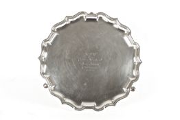 A silver pie crust trayhallmarked Birmingham 1924, Elkington and raised on three hoof feet, with