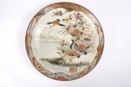 A large early 20th century Japanese Imari chargerdecorated with a scene of geese in flight and