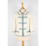 A Chanel cream boucle jacket.
with light blue trim, gold coloured Chanel buttons, two faux pockets