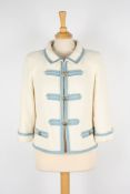 A Chanel cream boucle jacket.with light blue trim, gold coloured Chanel buttons, two faux pockets