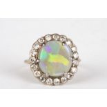 An opal and diamond cluster ring
set with large opal surrounded by nineteen small diamonds, in an