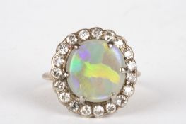 An opal and diamond cluster ringset with large opal surrounded by nineteen small diamonds, in an