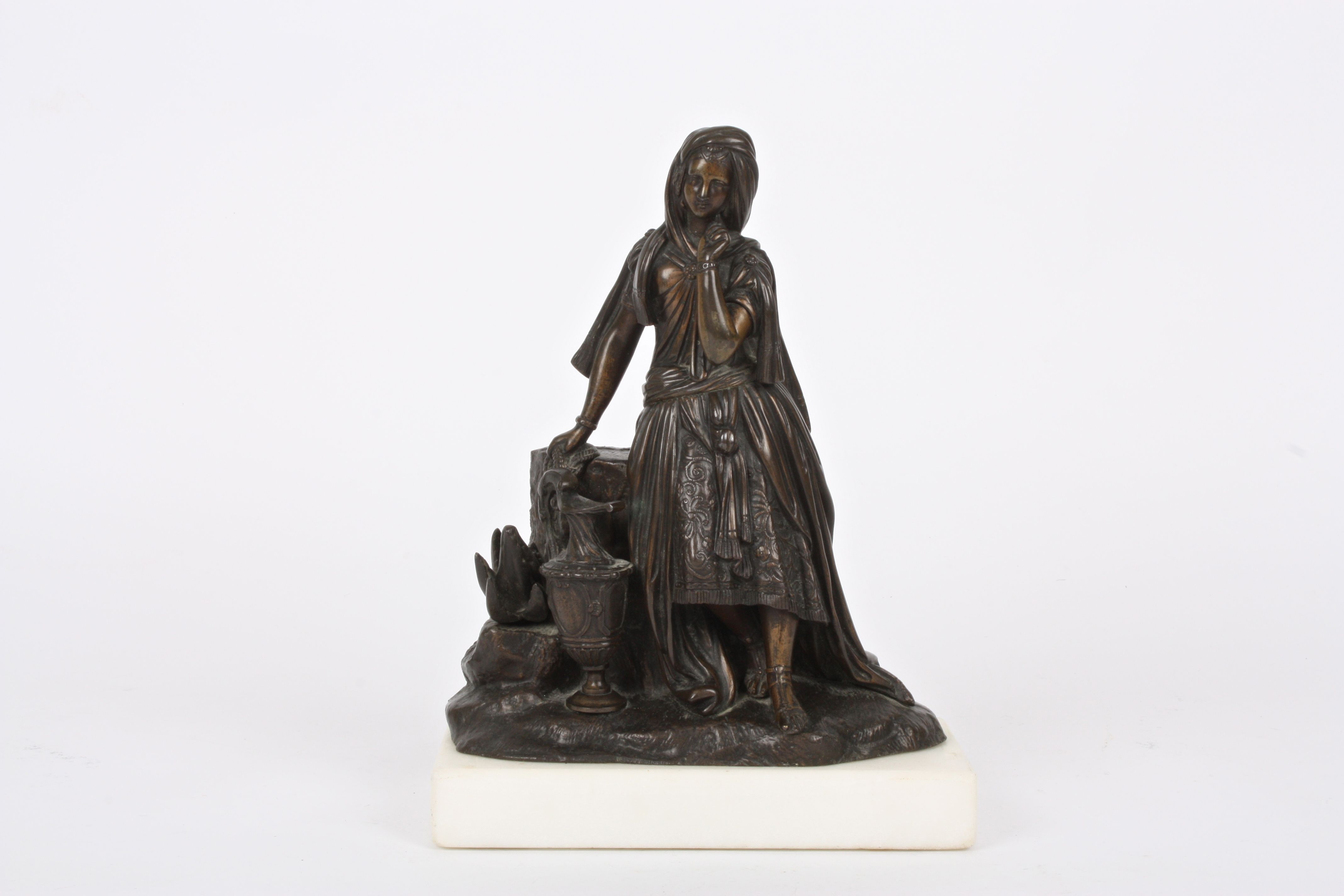 A 19th Century French bronze girl
stood wearing flowing robes stood beside a rocky pedestal and a