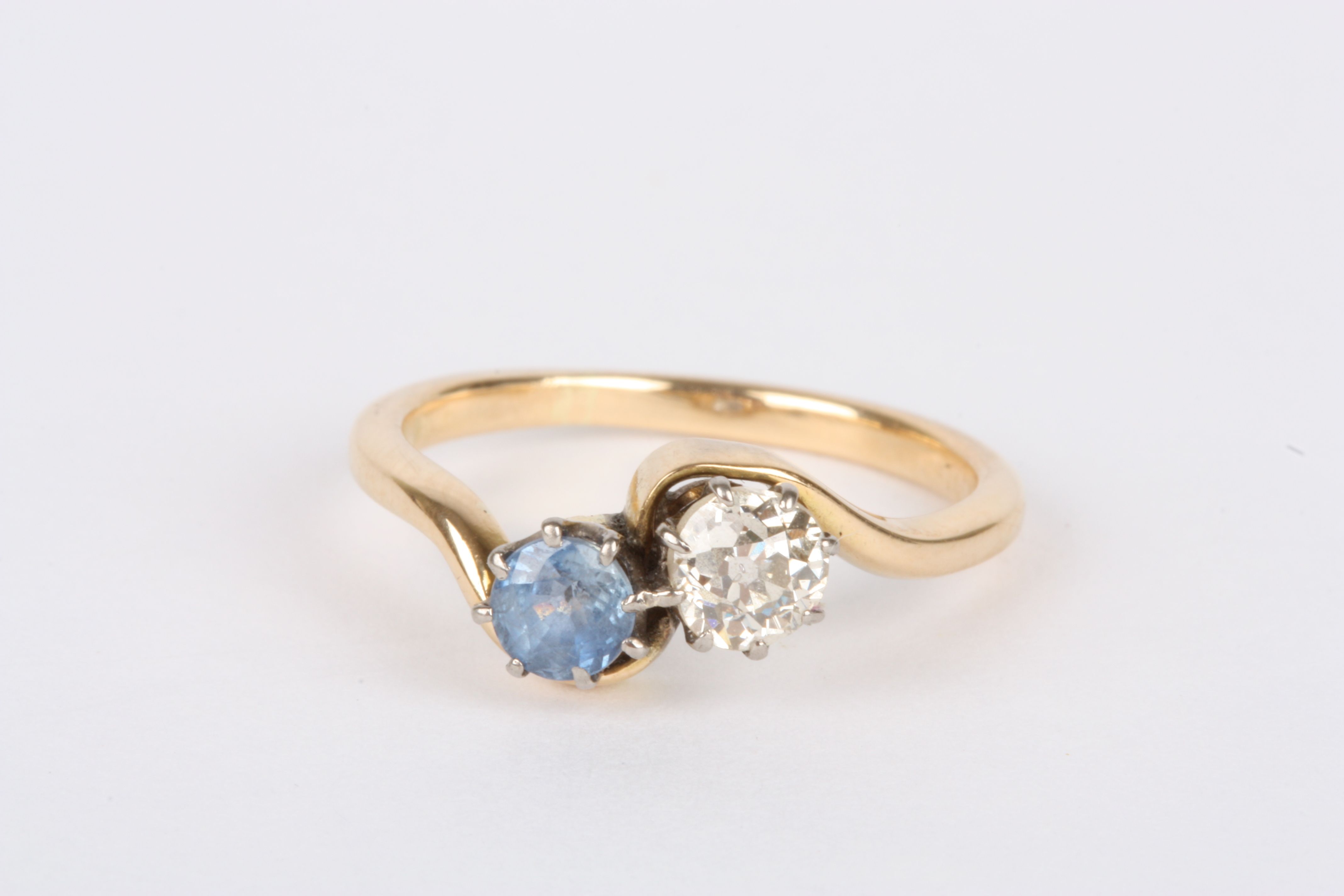 A gold coloured metal, diamond and sapphire two stone ring
set with diamond weighing approximately