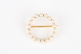 An Edwardian 15ct gold and pearl broochof plain circular form, mounted with eighteen pearls on a