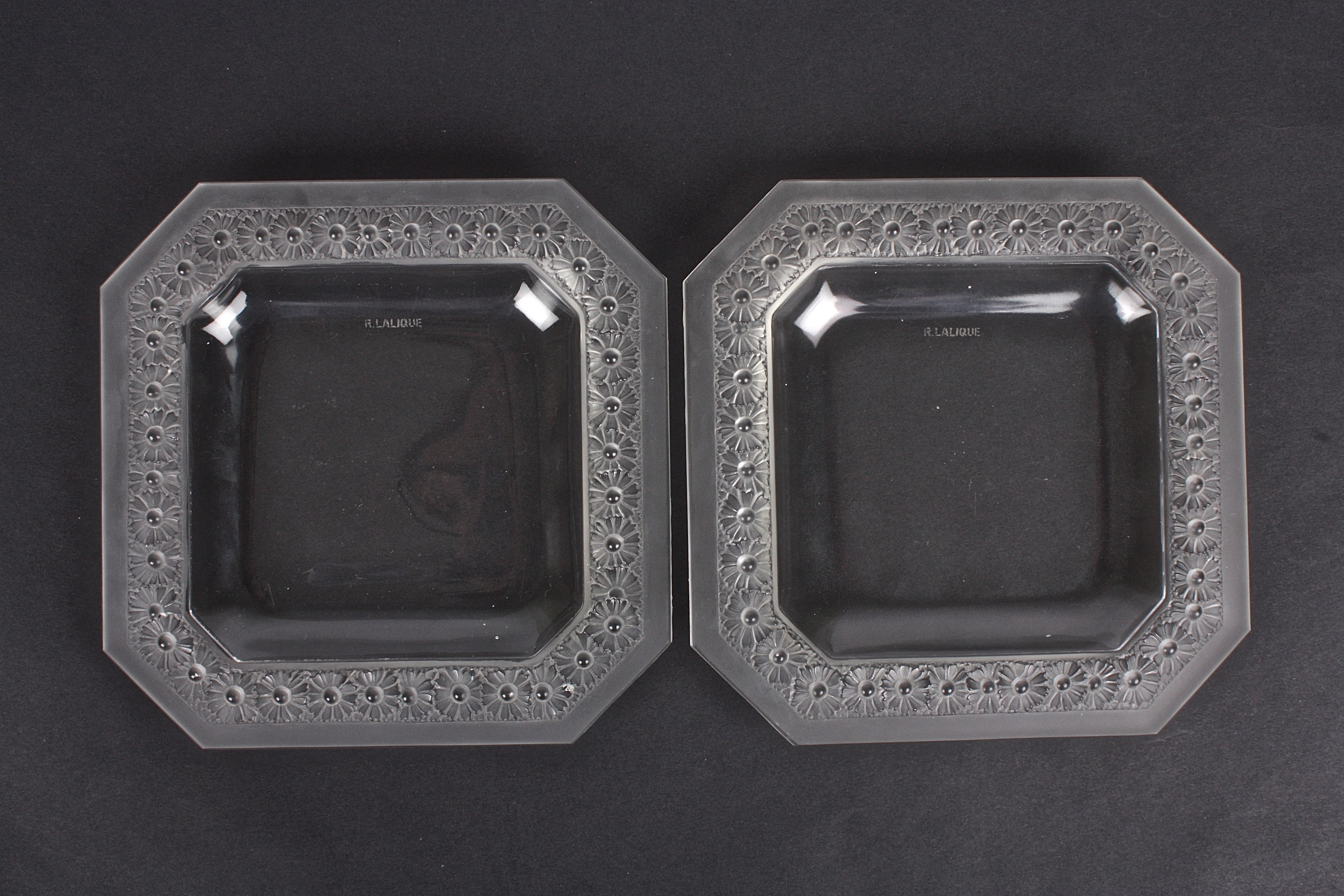 A pair of R. Lalique 'Paquerettes' square frosted glass dishes
the rims moulded with daisies, with