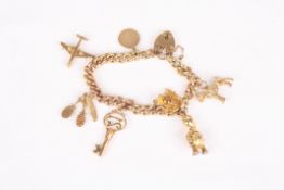 A 9ct gold charm bracelet the curb link bracelet with 8 charms including, aeroplane, dog, brush comb