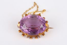 A Victorian amethyst oval broochset with large faceted amethyst, in a yellow metal six claw mount