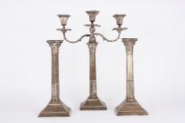 A pair of George V silver Corinthian column candlesticks and a matched Edwardian candelabra,