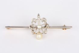 An Edwardian gold, diamond and pearl bar broochset with floral motif crested by a pearl, on a