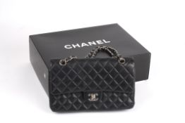 A leather quilted black Chanel handbag. the leather double flap bag from Chanel featuring a