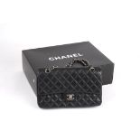 A leather quilted black Chanel handbag. 
the leather double flap bag from Chanel featuring a