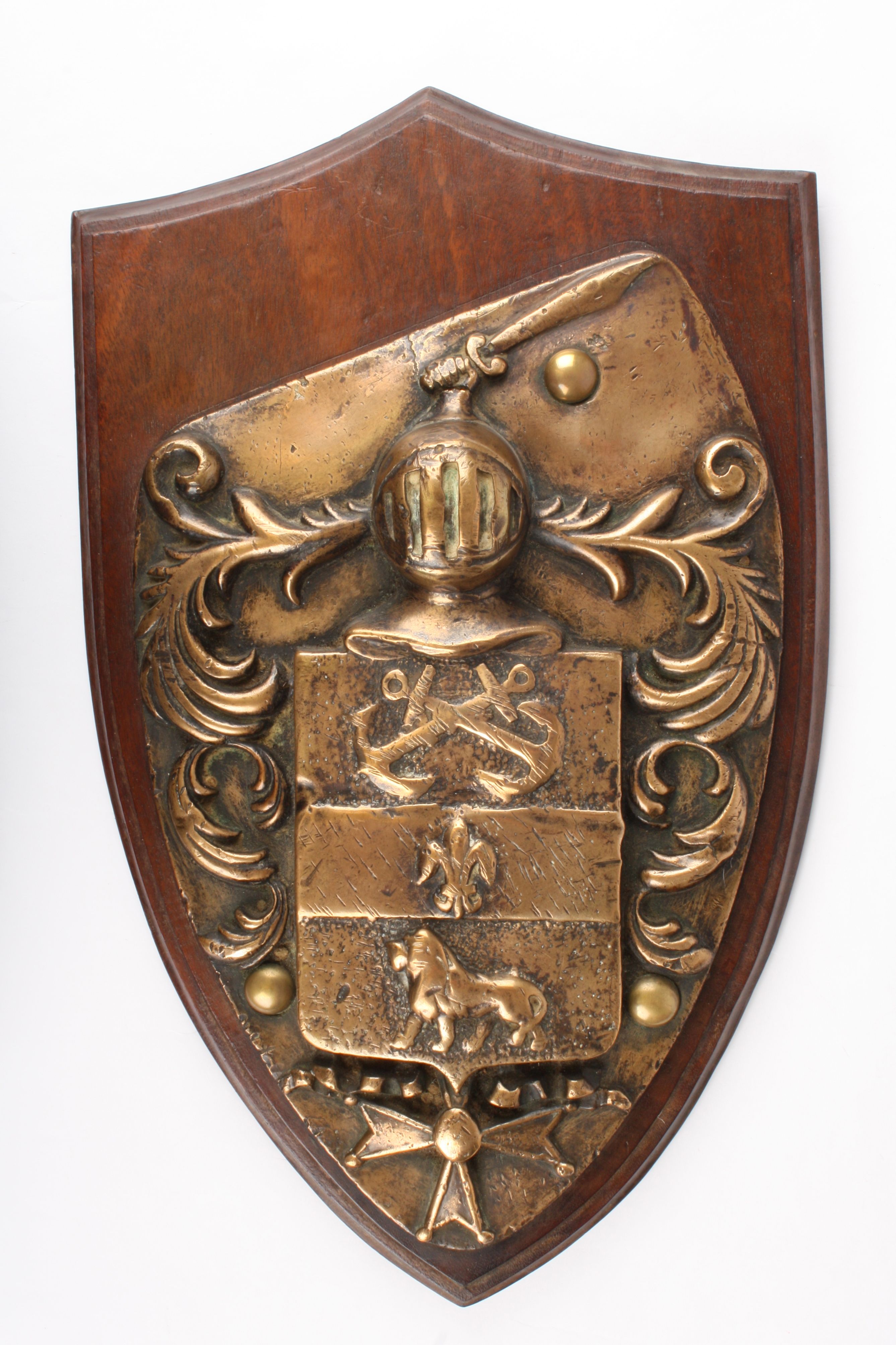 A large and heavy 19th century brass coat of arms
shield shaped and moulted in relief with a knights