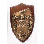 A large and heavy 19th century brass coat of arms
shield shaped and moulted in relief with a knights