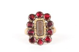 A gold and garnet mourning ringset with a central panel of woven hair surrounded by ten faceted