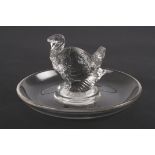 An R. Lalique clear glass ring dish
mounted with a model of a turkey. Etched signature to base 'R.