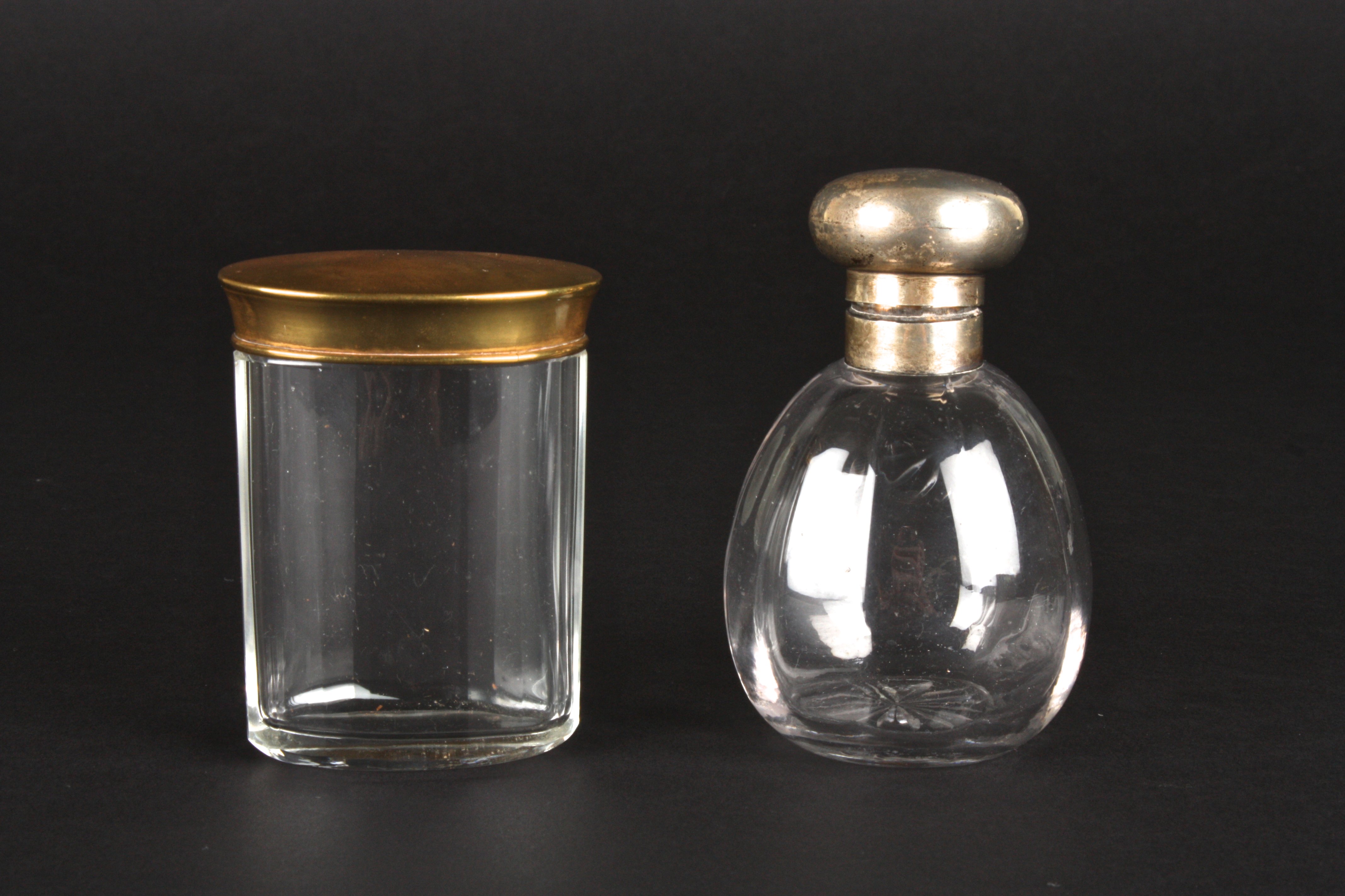 A silver topped glass scent bottle
hallmarked Birmingham 1925, together with a brass topped dressing