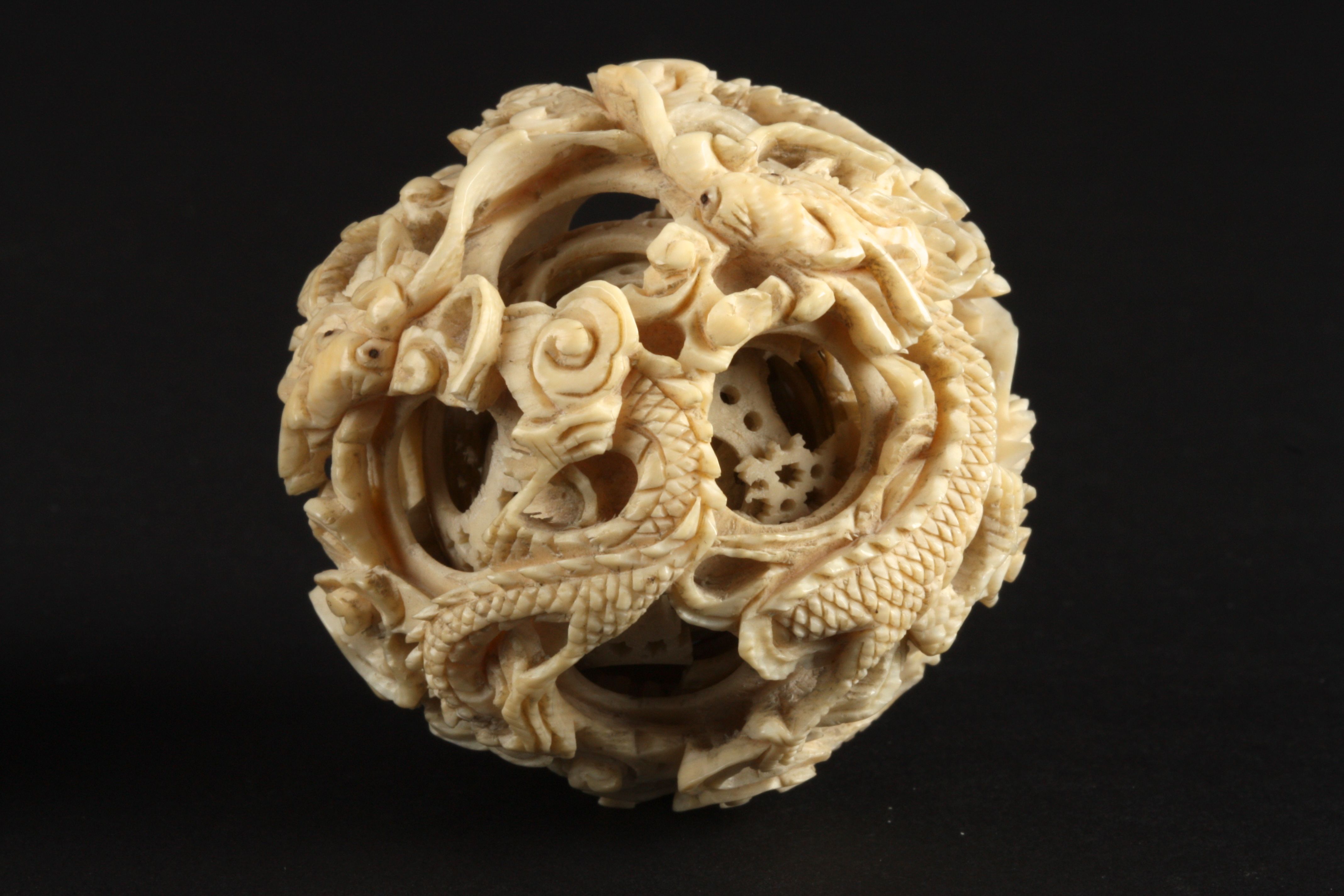 A Chinese ivory puzzle ball
late 19th/early 20th century
deeply carved with dragons, raised on - Image 2 of 2