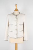 Two Chanel boucle jackets. The first cream jacket with black trim, two pockets to front, two beaded