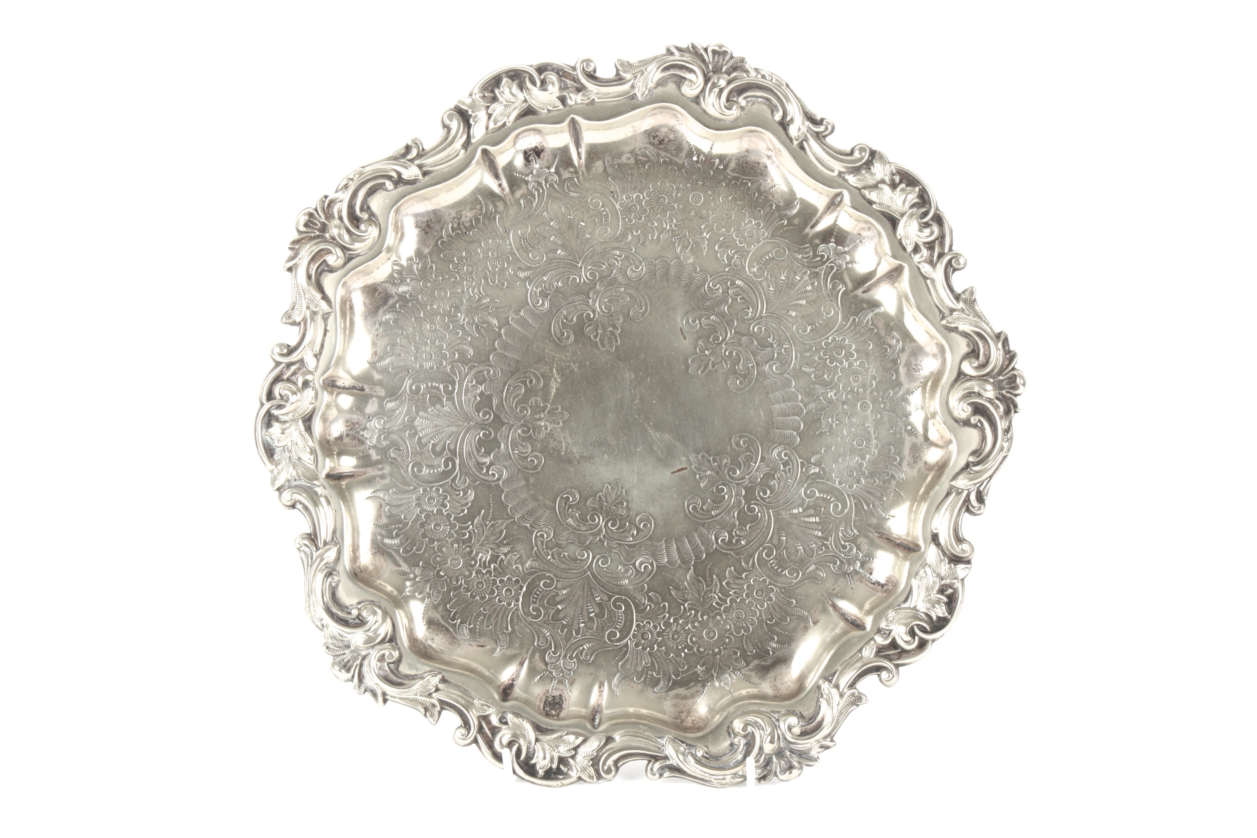 A silver plated tray
of pie-crust form, decorated with scrolls and foliageDimensions: diameter