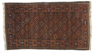 A small brown and red ground Persian rugdecorated with geometric designs on a brown field