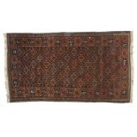 A small brown and red ground Persian rug
decorated with geometric designs on a brown field