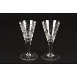 A pair of late 18th century engraved hunting drinking glasses
one decorated with a bear hunting